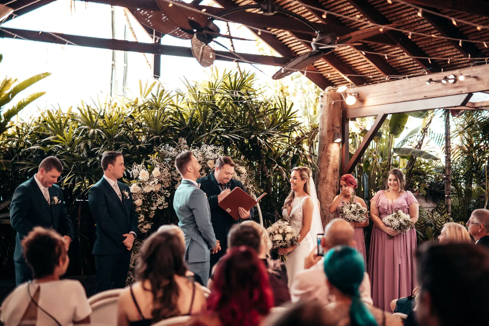 Indoor Gold Coast ceremony surrounded by tropical plants and florals
