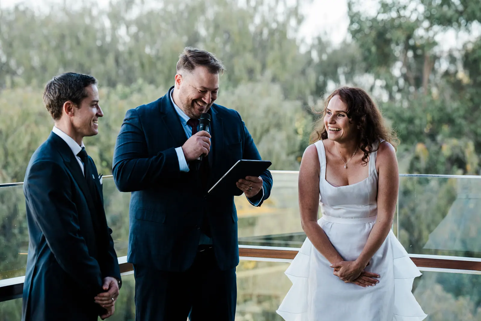 Ben, holding a microphone and laughing with a couple